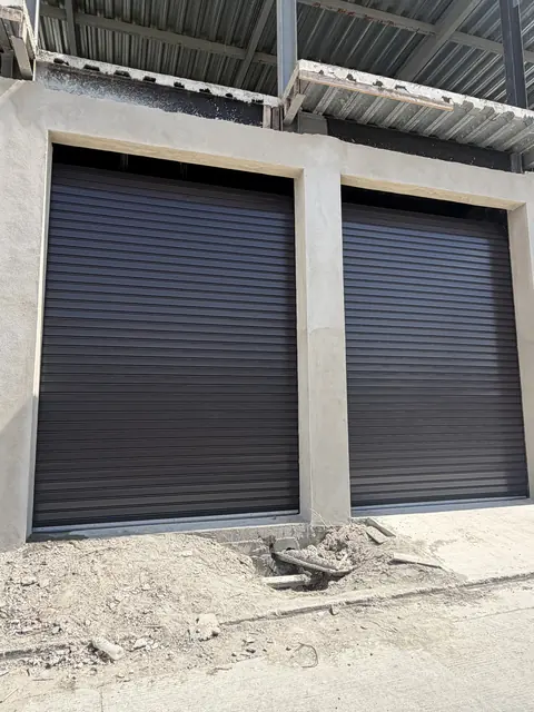 Dos cortinas de acero negras en un acceso