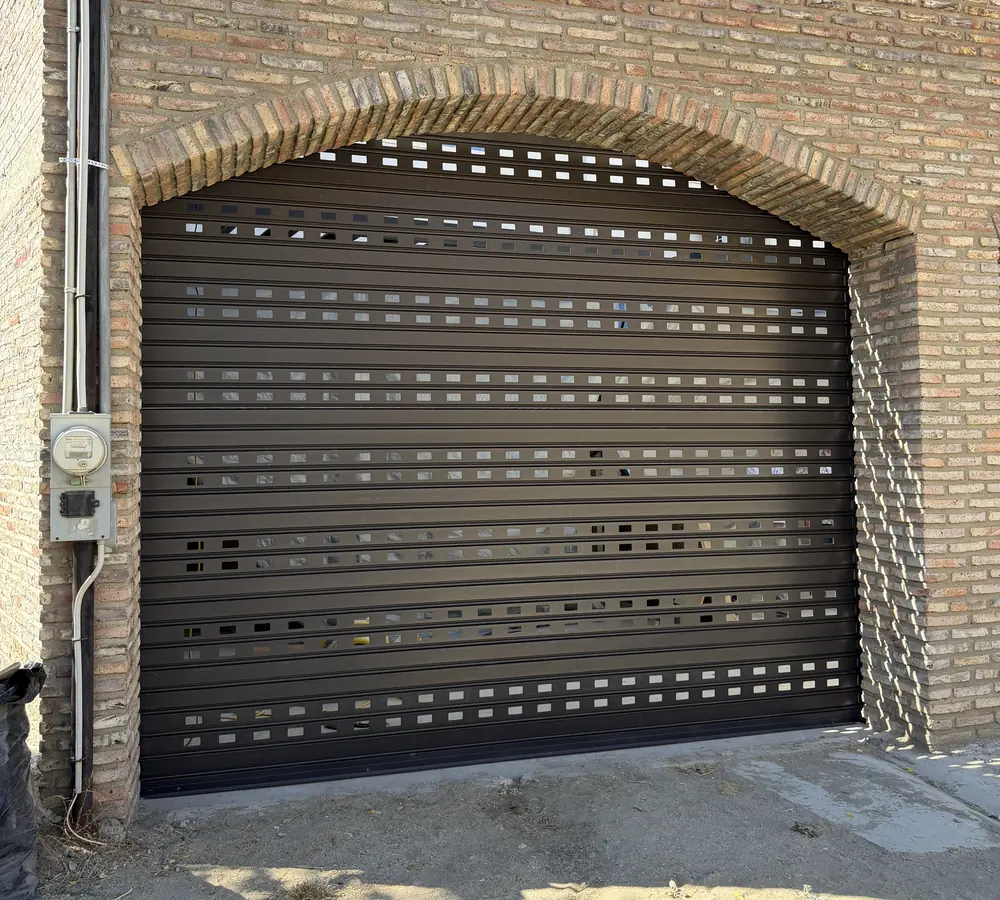 Cortina de acero perforada en un arco de ladrillo